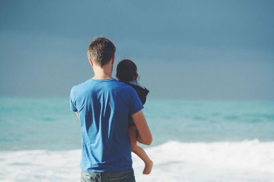father and child at ocean