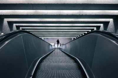 man walking down escalator