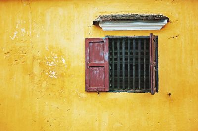 barred window on yellow wall