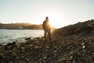 man stands on rocky beach