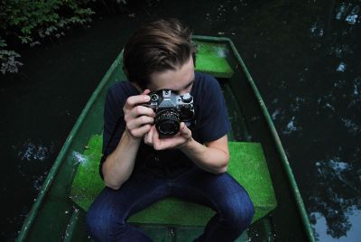 boy in boat with camera