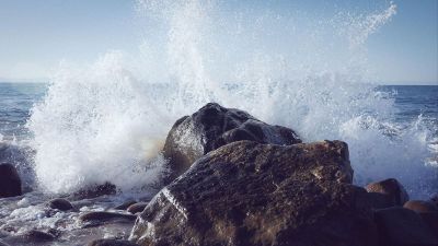 ocean splashing against shore line rocks