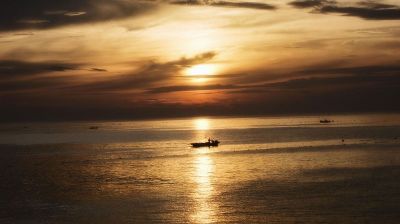 a boat under a sunset