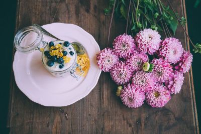 blueberries and cream next to purple flowers