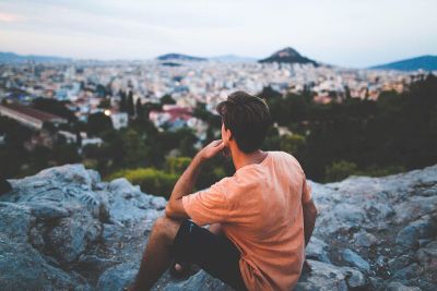 man pondering on top of mountain