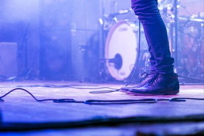 lower limbs of a stage performer holding a mic