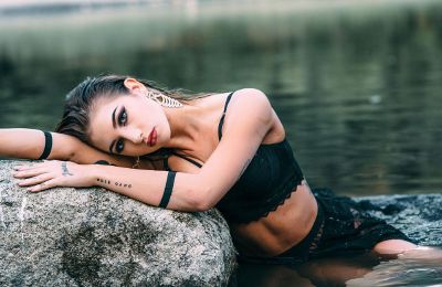 woman laying on rock in water