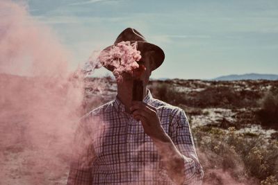 man blowing pink object