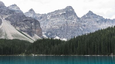 a lake with trees and mountains in the background