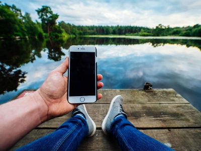 man holding phone at a dock