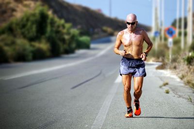 shirtless man jogging wearing sunglasses