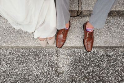 couple sitting on pavement shoes shot