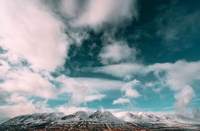 white clouds in the blue sky over mountains