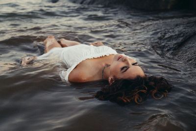 clothed woman lying in water