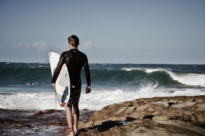 man carrying surfboard