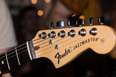 person holding a fender guitar