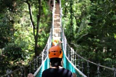 hikers walk across a suspension bridge