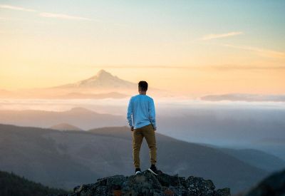 man standing on top of a mountain