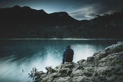 man sitting look at lake