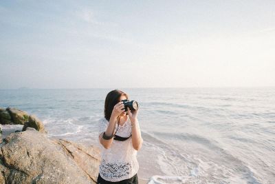 woman taking photograph at beach