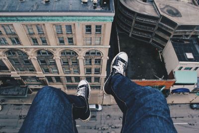 legs dangling over city