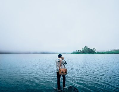 man taking photo of lake