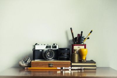 camera on table with pencils