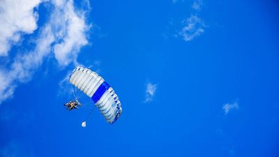 two people in sky with parachute