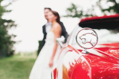 newlyweds by a car