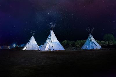 white tipis rise against starry sky