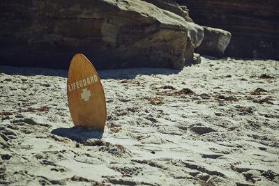 lifeguard sign standing in beach sand