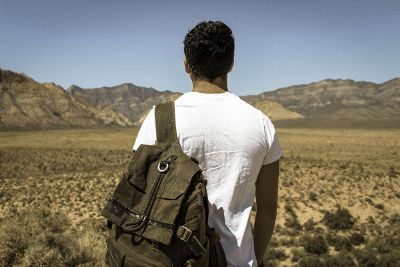 backpacker looking out over desert and mountains