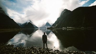 man at a lake with mountains