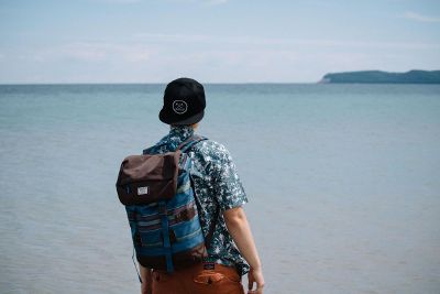 man with rucksack overlooking ocean