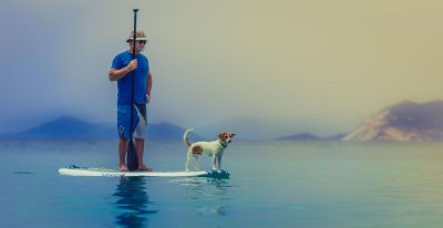 man on surf board with dog