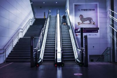 woman ascending escalator alone