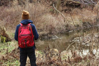 overlooking pond with a red backpack