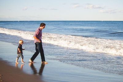dad and son walk on beach