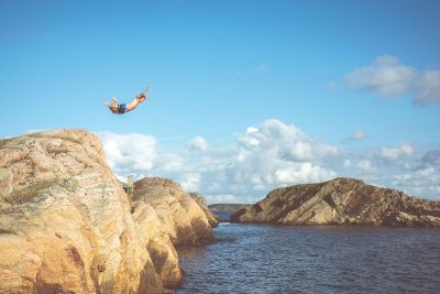 guy cliff jumping into ocean