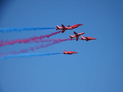 five red jets releasing colored smoke