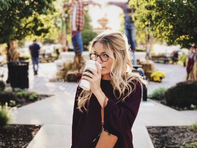 young girl drinking coffee in a park