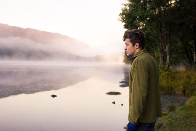 young man looking at a river