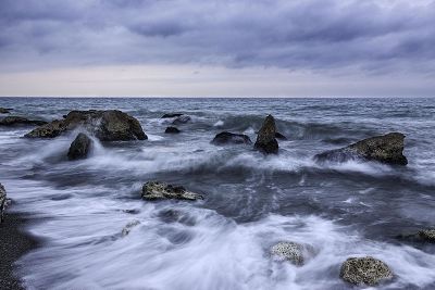 rocky ocean with dark clouds