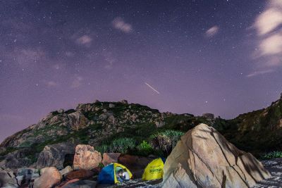 rocky hill on a blueish sky with stars