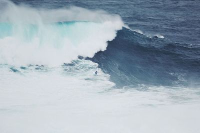 huge wave crashing on surfer