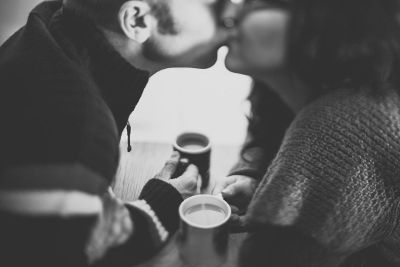 couple kissing with coffee