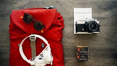 red backpack with camera and headphones