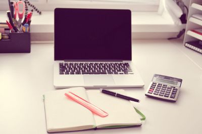 laptop stitting on a desk with a calculator