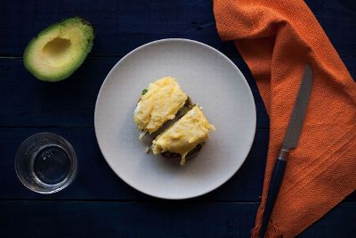 a meat with potato topping with avacado on the side