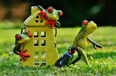 statue of three frogs and house